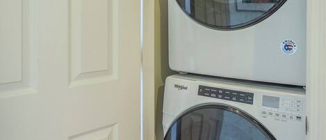 Une buanderie équipée de deux machines à laver Whirlpool à chargement frontal, superposées.