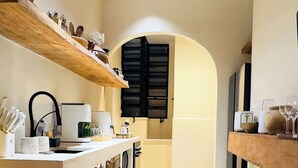 A narrow kitchen with wooden beams, a central island, and a built-in wine rack. - Ipanema Premium Design · Renovated · Steps to Beach & Subway (Rio de Janeiro)