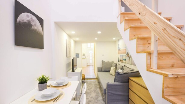 Ein modernes Interieur mit Essbereich, Treppe und Wohnzimmer.