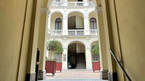 Un pasillo con una escalera central que conduce a un edificio de varios pisos con balcones.