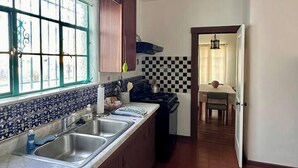 Cuina amb un taulell llarg, dues dutxes i una finestra amb baranes decoratives.