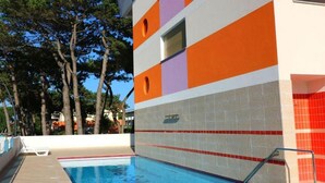 Área de piscina com paredes azulejadas e água azul cristalina.