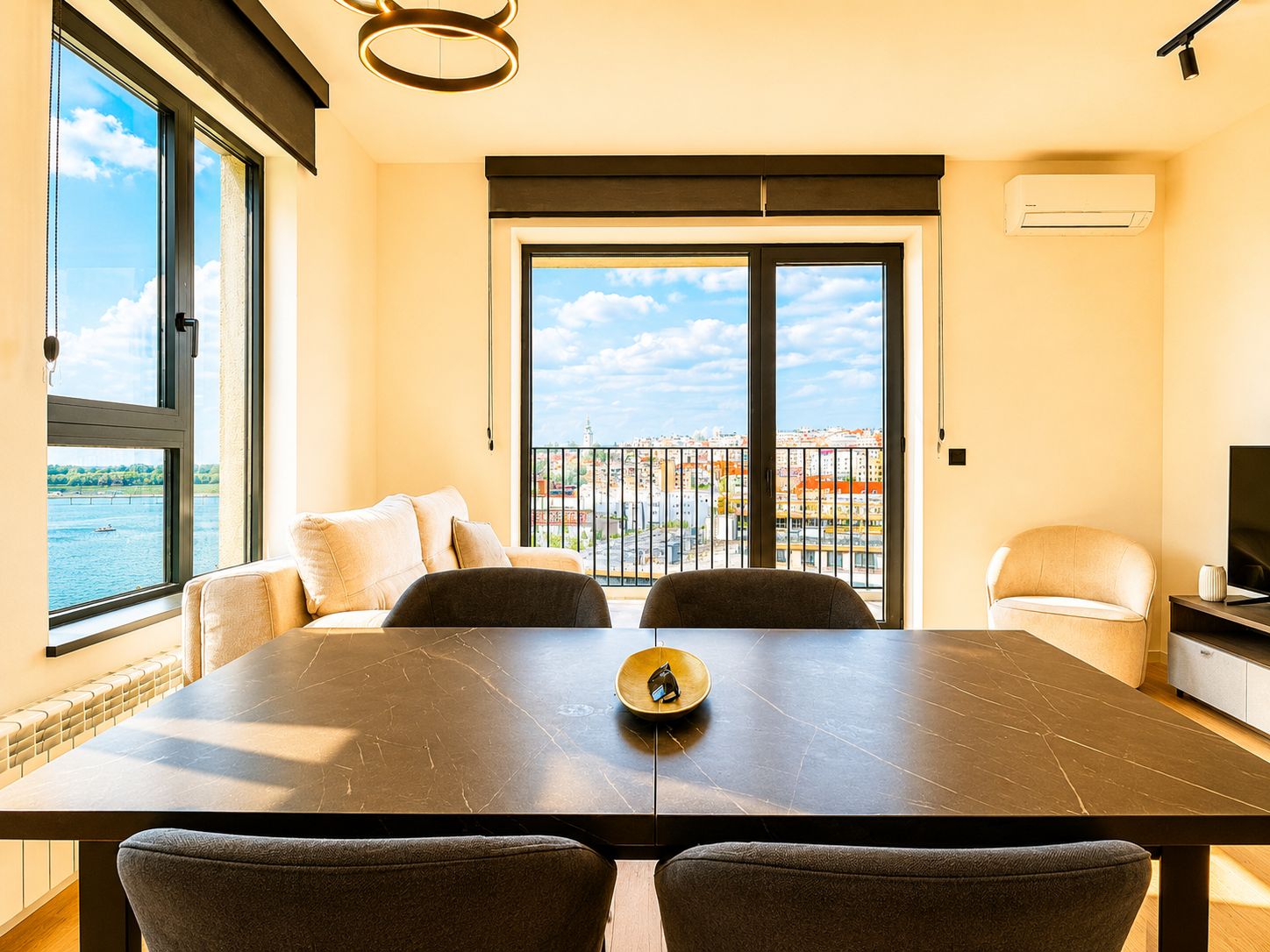 Un salon moderne avec une grande fenêtre, une table à manger et un canapé.
