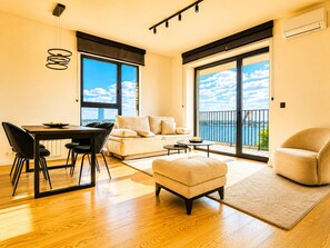Un salon moderne avec un coin repas, de grandes fenêtres et un balcon offrant une vue dégagée.