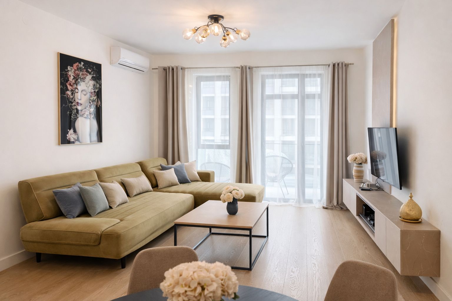 A modern living room with a sectional sofa, a coffee table, a flat-screen TV, and a large window with curtains.