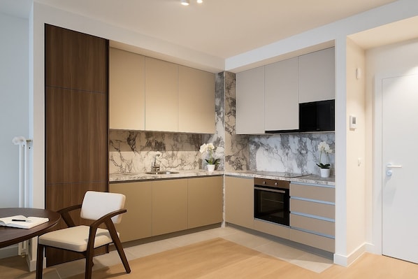 Apartamento superior, patio | Cocina privada | Frigorífico, microondas, horno y placa de cocina