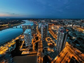 A high-rise building complex with multiple floors, a central courtyard, and a river in the background. - Boutique Hotel Echo Residence (Belgrade)