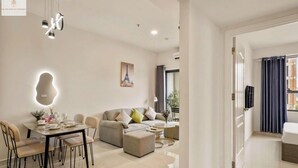Un salon moderne comprenant un coin repas, un ensemble de canapés et une table basse.