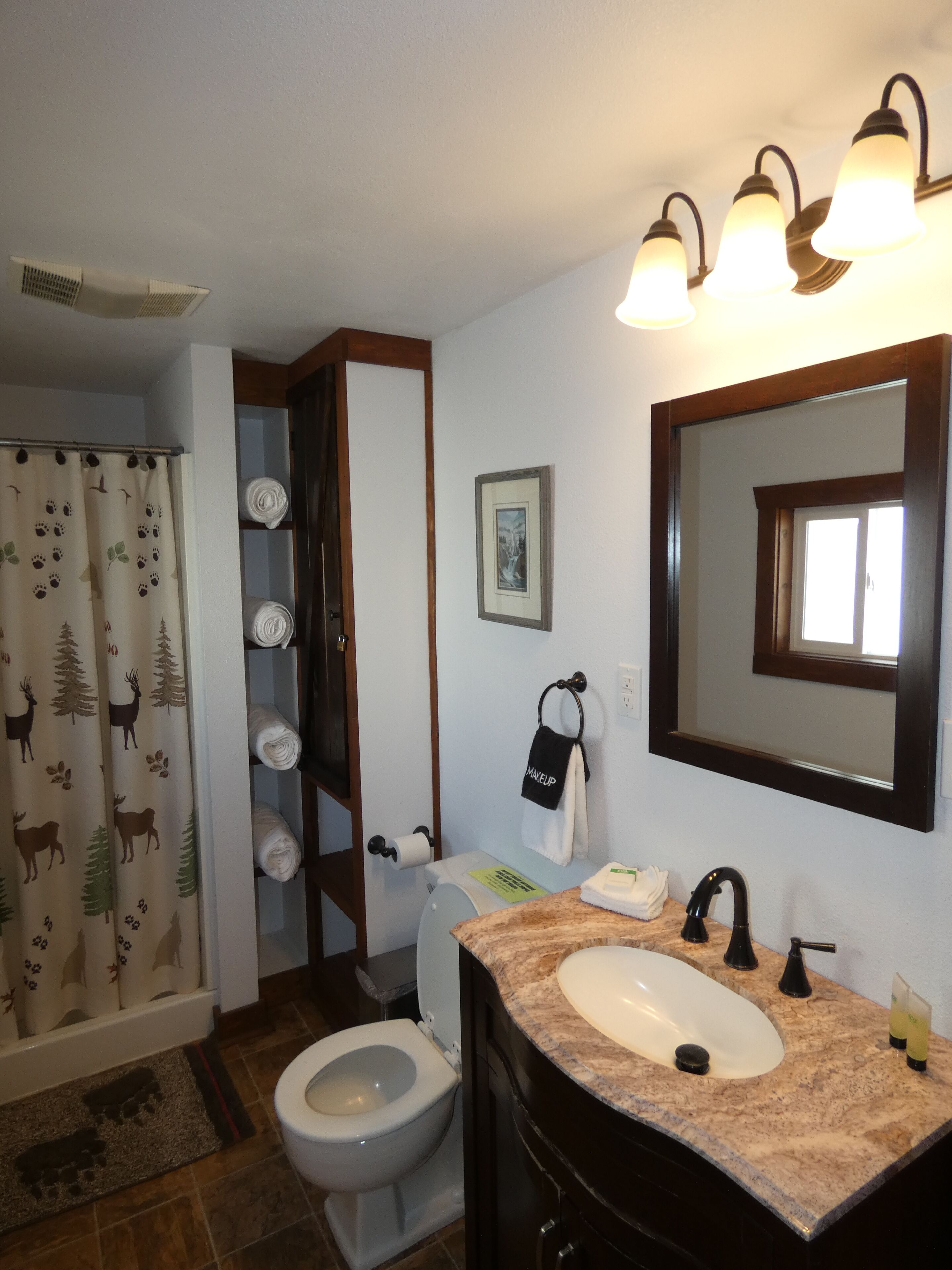 Un baño con inodoro, lavamanos y cortina de ducha.