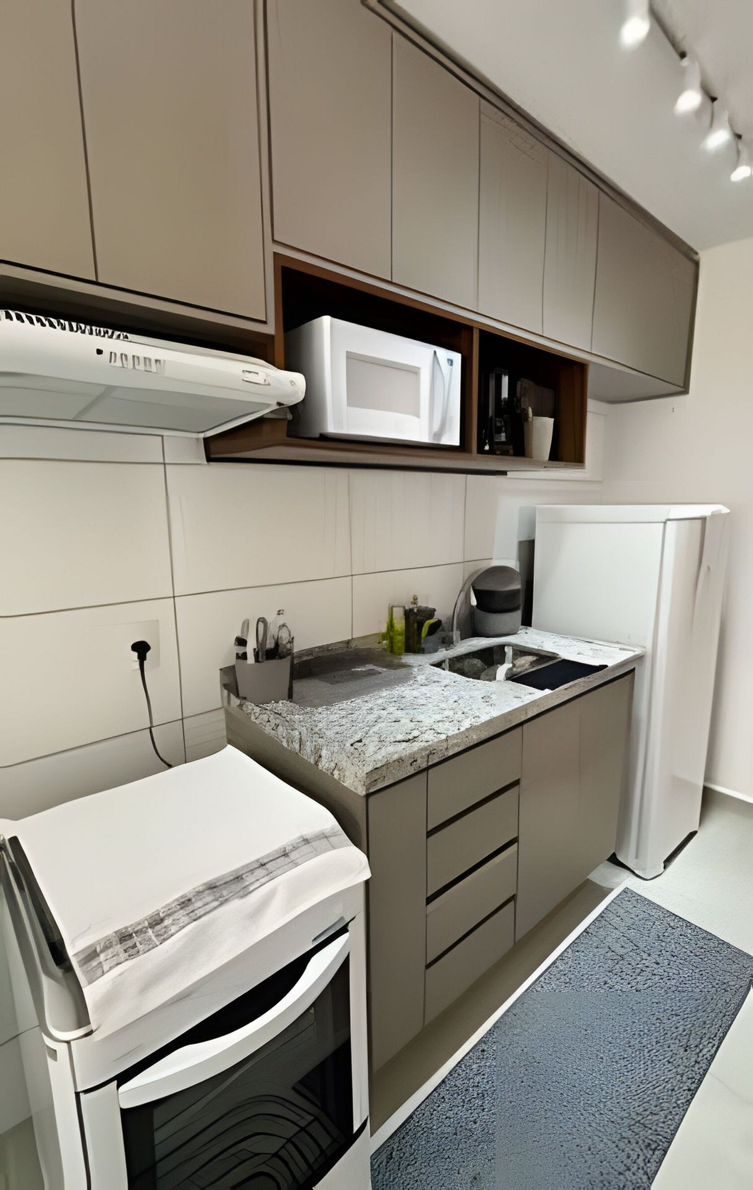 Una cocina moderna con microondas, refrigerador y un lavamanos pequeño.