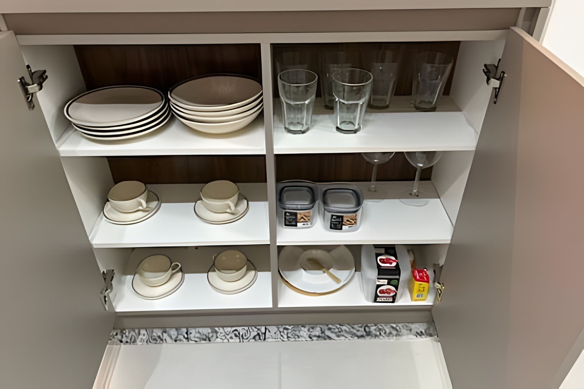 Un armari de cuina amb prestatges que contenen plats, tasses, vasos i recipients.