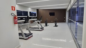 A modern gym with treadmills, stationary bikes, and a fire extinguisher on the wall. - Mel Prime Executive Loft Extrema MG (Extrema)