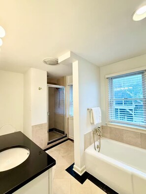 A modern bathroom with a bathtub, a shower, and a vanity with a sink. - Boston Single House 2BR - Backyard + Walk to BCEC & Seaport (Boston)