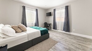 Une chambre à coucher avec un lit, un bureau et une télévision.