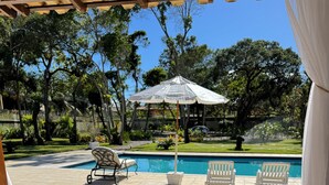 Una terraza de madera con piscina y sillas de descanso.