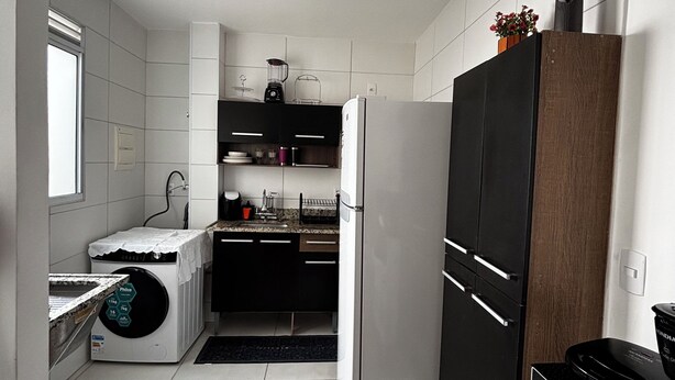Una cocina moderna con lavadora y secadora integradas, un refrigerador y un microondas.