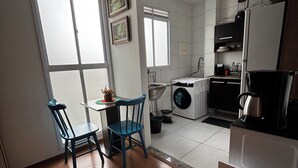 Una cocina compacta con comedor, lavadora y refrigerador.
