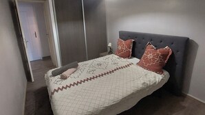 Una camera da letto con un letto, un comodino, una lampada e un armadio.