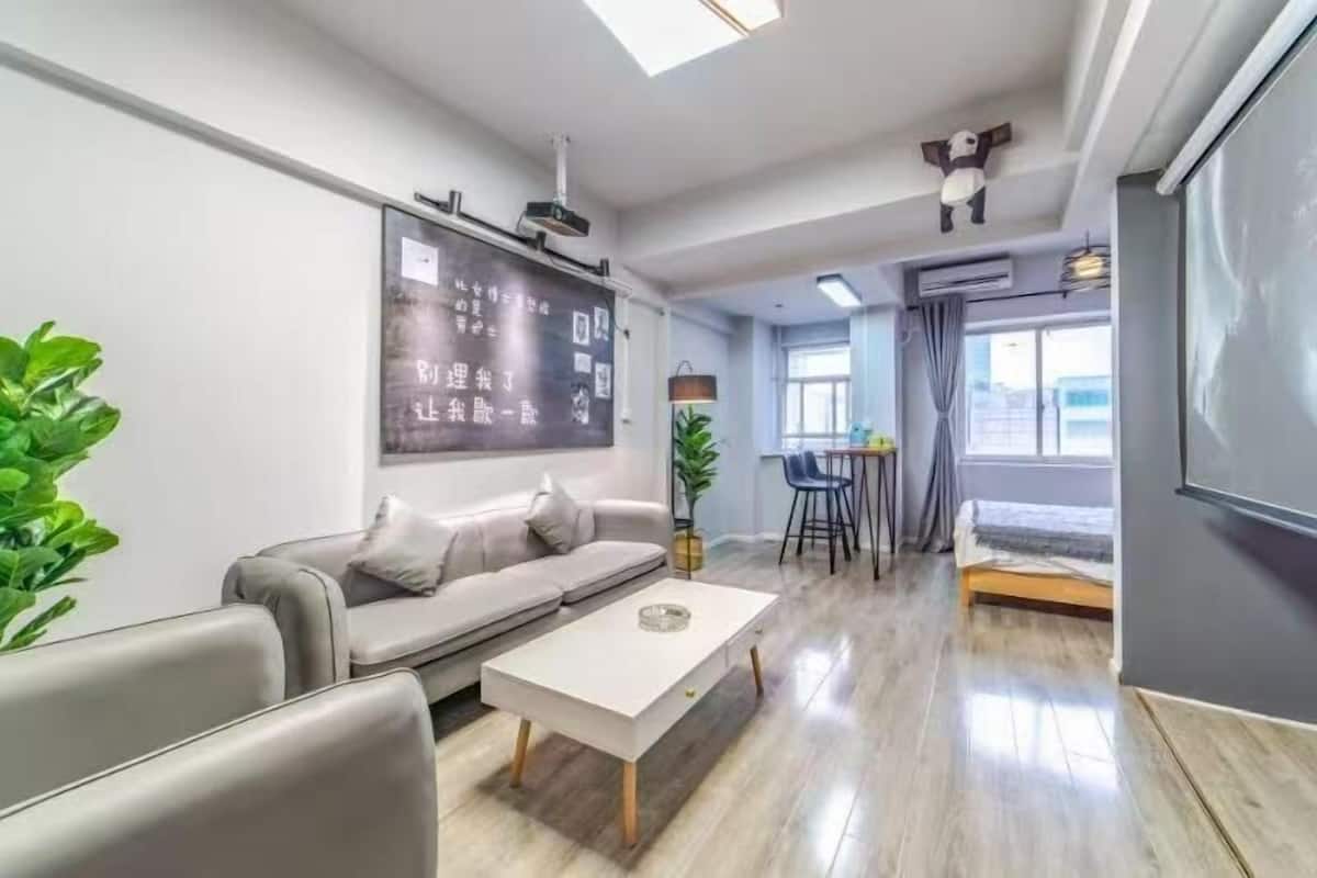 Ein modernes Wohnzimmer mit einer Couch, einem Couchtisch und einer großen Tafel an der Wand.