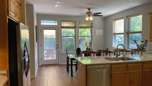 A kitchen with wooden cabinets, a stainless steel refrigerator, a dishwasher, and a window with blinds. - Comfort and calm in Ashland (Ashland)