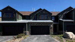 A two-story house with a stone facade and multiple garage doors. - Snowcreek Resort Vacation Rental 1430 (Mammoth Lakes)