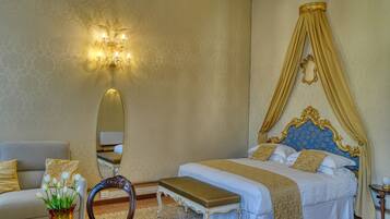 A bedroom with a bed, a bedside table, a chair, a mirror, and a wall-mounted light fixture.