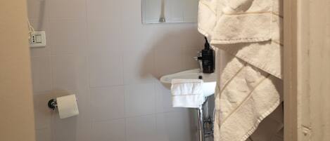 A bathroom with a toilet, sink, and towel rack.