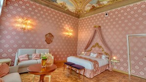 A room with a four-poster bed, a sofa, a round table, and a chandelier. - PALAZZO MALIPIERO TREVISAN - LE TRE DIMORE D'EPOCA (Venice)