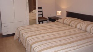 A bedroom with a bed, a chair, a nightstand, and a wardrobe. - Apartments Snježana (Sali)