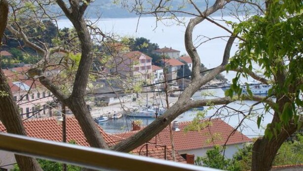 A coastal town with buildings, a marina, and boats. - Apartments Snježana (Sali)