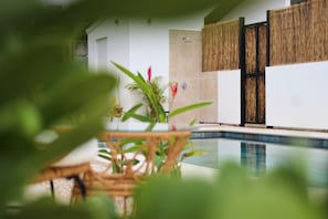 A pool area with a bamboo wall and a small table with plants. - Villa with 3 suites, private pools, comfort, and relaxation (Provincia de guanacaste)