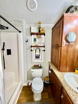 A compact bathroom with a shower, toilet, and sink. - Luxury Micro Retreat| Spa Amenities|Fire Pit|Pet Yard (Collin County)