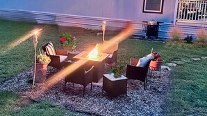 An outdoor patio with a fire pit and seating. - Luxury Amenity-loaded Tiny Home w/ Pet Yard +EVCharg (Collin County)