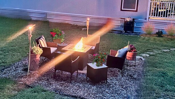 Une terrasse extérieure avec un foyer et des sièges.