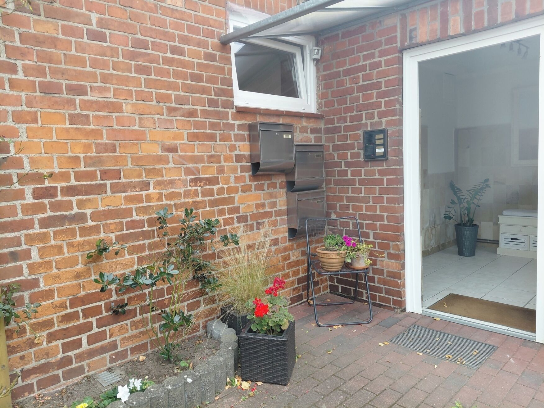 A brick exterior with a sliding glass door leading to a white interior.