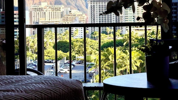 A balcony with a view of a cityscape, including tall buildings and a mountain in the distance. - Ocean & Diamond Head-view studio in Waikiki (Honolulu)