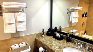 A bathroom with a granite countertop, two sinks, a toilet, and a large mirror. - Ocean & Diamond Head-view studio in Waikiki (Honolulu)