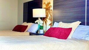 A hotel room with two beds, a nightstand with a lamp, and a large wall mural. - Ocean & Diamond Head-view studio in Waikiki (Honolulu)