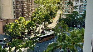 A high-rise hotel with a pool area, palm trees, and a view of the ocean. - Ocean & Diamond Head-view studio in Waikiki (Honolulu)