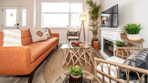 A living room with a sofa, coffee table, and a fireplace. - Luxe Escape Duo - 8 Beds - Sleeps 22 - 4 Car Garage (Edmonton)