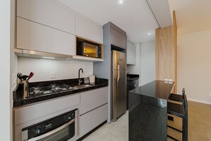 A modern kitchen with stainless steel appliances, a microwave, and a built-in oven. - Morse Residencial Flipchave MOR000 (Joinville)