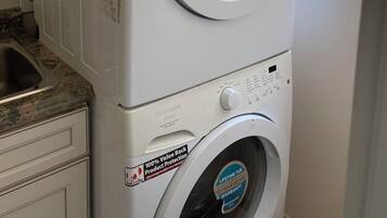 A front-loading Frigidaire washer and dryer unit with a stainless steel control panel, a 10-year motor warranty, and a 100% value back product protection sticker.