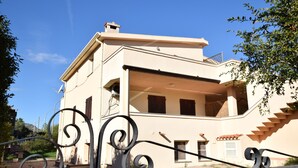 A two-story building with a flat roof, a balcony, and a staircase leading to the upper floor. - Fsg-pint02p1 in San Giovanni (Posada)