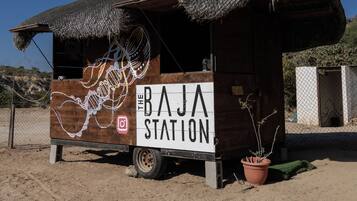 A small wooden structure with a thatched roof labeled "The Baja Station."