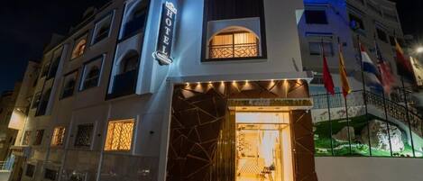 A hotel with a prominent entrance, a signboard, and a decorative facade.