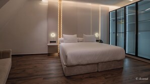 Ein modernes Schlafzimmer mit einem großen Bett, einem Nachttisch, einer Wandlampe und einem Schiebeglastüren-Kleiderschrank.