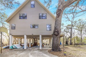 A two-story house with a covered porch, a ladder, and a picnic table. - River Retreat (Fort White)
