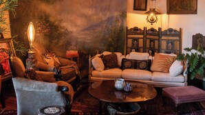 A cozy living room with a sofa, armchairs, a coffee table, and a hanging paper lantern. - Miss Scarlet 3-bedroom cottage in Historic downtown Hot Springs (Hot Springs)