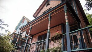 A two-story house with a porch, columns, and a balcony. - Miss Scarlet 3-bedroom cottage in Historic downtown Hot Springs (Hot Springs)