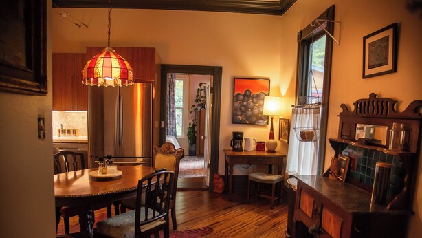 A dining area with wooden furniture, a chandelier, and a view into the kitchen. - Miss Scarlet 3-bedroom cottage in Historic downtown Hot Springs (Hot Springs)